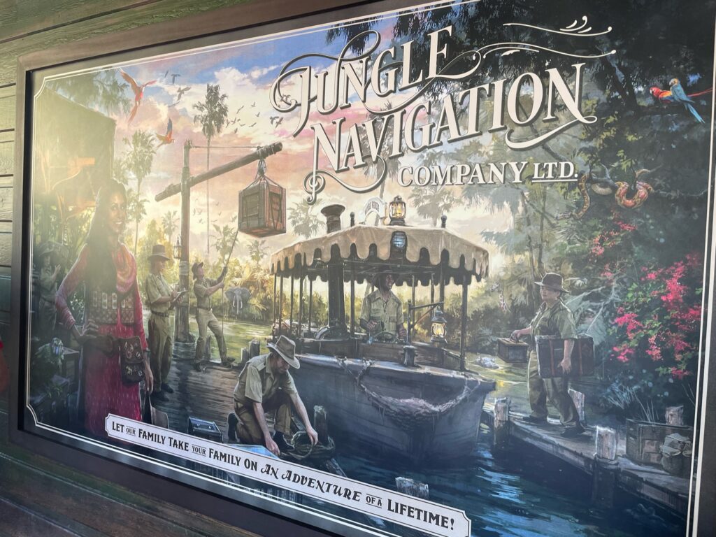 A vibrant promotional poster for 'Jungle Navigation Company Ltd.' depicting a lively river expedition scene with explorers, a boat guide, tropical wildlife, and lush vegetation. The caption reads 'Let our family take your family on an adventure of a lifetime!'